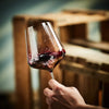 Vorsprung Biowein wird ins Glas zum Dekantieren eingeschenkt vor Holzweinkisten