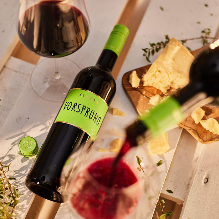 Biowein Vorsprung wird in Glas eingeschenkt bei Käse und Sonnenschein